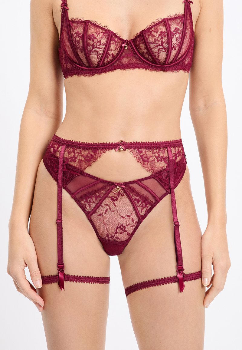 Burordeauxrotes Spitzen-Dessous-Set mit einem strukturierten BH, transparenten Details, dekorativer Hardware und Satinakzenten an den Strapshaltern.