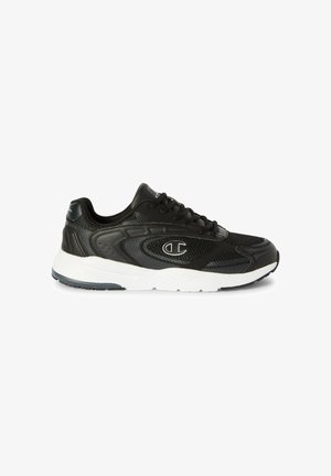 Zapatilla deportiva negra con suela blanca, parte superior de malla y material sintético, diseño con cordones y un logotipo en el lateral, mostrada de perfil.