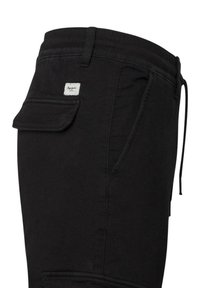 Schwarze Jogginghosen aus einem Baumwollmischgewebe mit einer Seitentasche, einem elastischen Bund und einem kleinen Markenlabel auf der Rückseite.