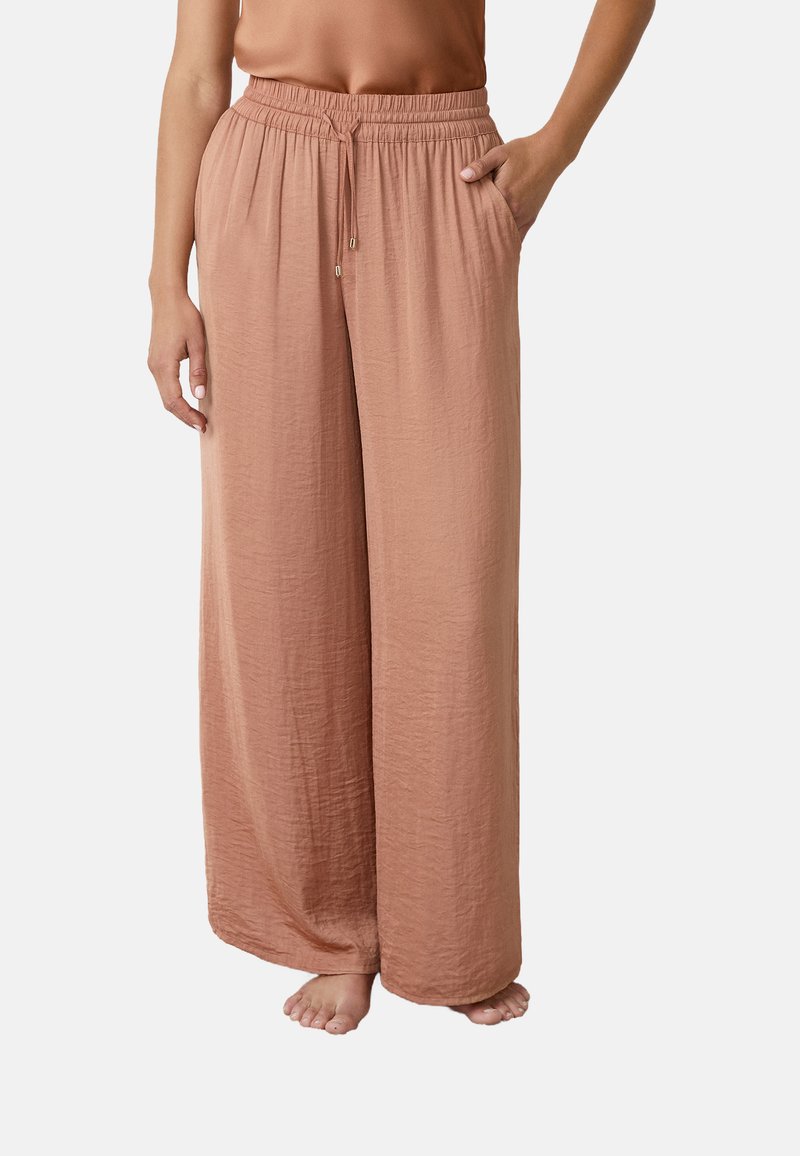 Wijdgevende broek van zachte, gestructureerde stof met een elastische tailleband. Kleur: gedempt perzik. Inclusief zijzakken en een trekkoorddetail.