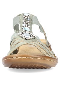 Lichtgroene sandaal van zacht stof, met kraal- en steentjesversieringen langs de band, een getextureerde tan zool en leren accenten.