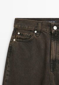 Mörkbruna denimjeans med en klassisk femficksdesign, silverfärgad hårdvara och synliga söm detaljer. Lappen säger "Massimo Dutti."
