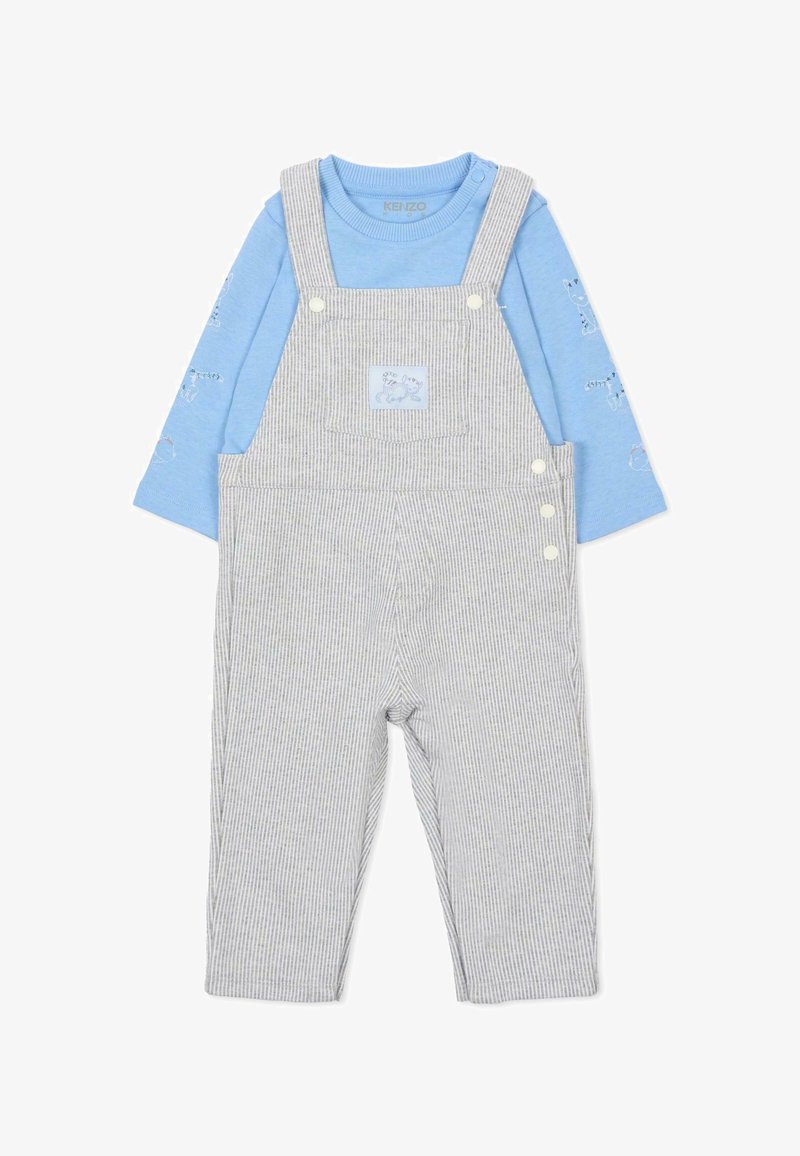 Tuta grigia a righe con bretelle regolabili e bottoni bianchi, abbinata a una camicia a maniche lunghe azzurro chiaro con disegni di animali.