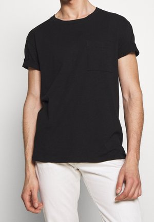T-shirt nera a maniche corte in cotone, con maniche arrotolate e tasca sul petto. Tessuto testurizzato con una finitura liscia.