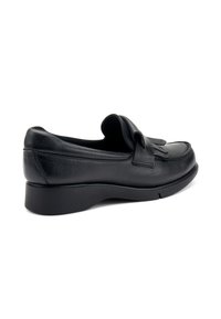 Mocassin pour homme en cuir noir avec un talon bas et des franges sur le devant, présenté en profil latéral sur fond blanc.