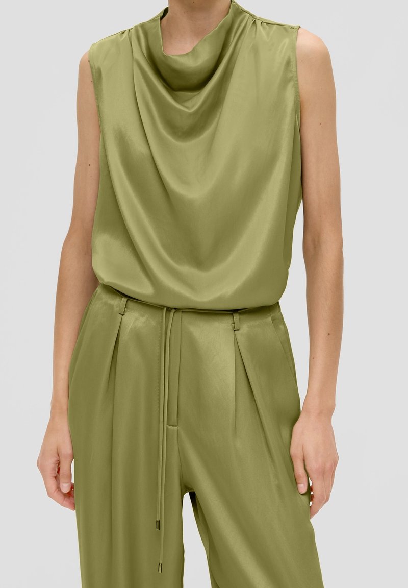 Haut sans manches en satin vert olive avec encolure drapée, associé à un pantalon en satin assorti taille haute avec plis et taille à cordon.