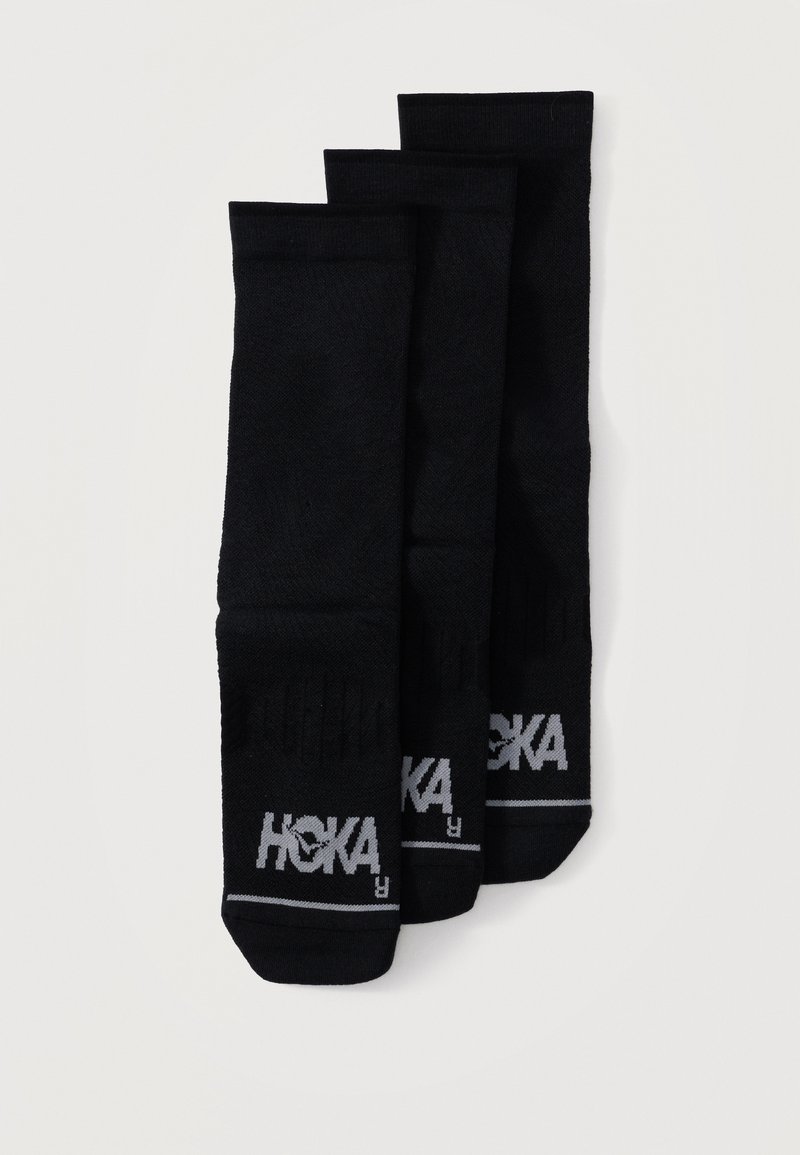 Τρία ζεύγη μαύρες κάλτσες πλήρους μήκους με γκρι λογότυπα "HOKA" στα δάχτυλα, τοποθετημένες επικαλυπτόμενες σε λευκό φόντο.