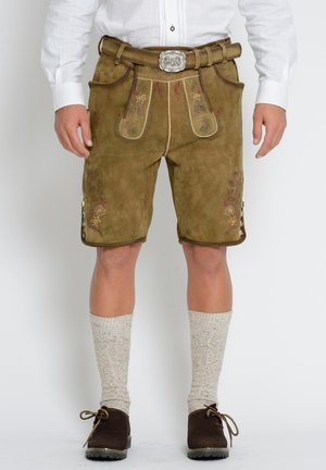 Ruskih antilop lederhosen s cvjetnim vezom, visokim strukom i detaljima na gumbima. Upareni s visokim čarapama s teksturom i tamnim cipelama.