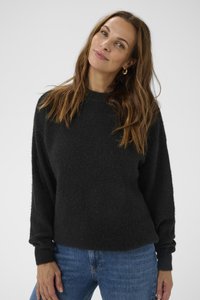 Black wool blend sweater with a textured surface, round neckline, and long, slightly puffed sleeves. Styled with blue denim jeans.