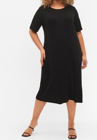 Abito nero a coste con maniche corte, lunghezza al ginocchio, dotato di scollatura rotonda e tasche laterali. Tessuto morbido e vestibilità comoda.