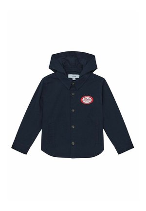 Mørkeblå hættetrøje med knaplukning, to sidelommer og et rødt oval patch på brystet med teksten "Reiss Est. 1971."
