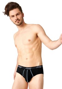 Slip in cotone nero con una linea d'accento blu, caratterizzato da una vita con logo. Texture liscia, design aderente e taglio moderno.