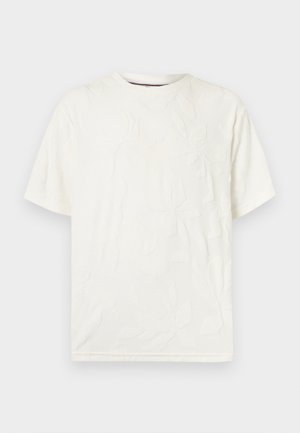 T-shirt blanc à manches courtes et col rond avec un motif abstrait texturé subtil sur le devant, présenté sur un fond clair uni.