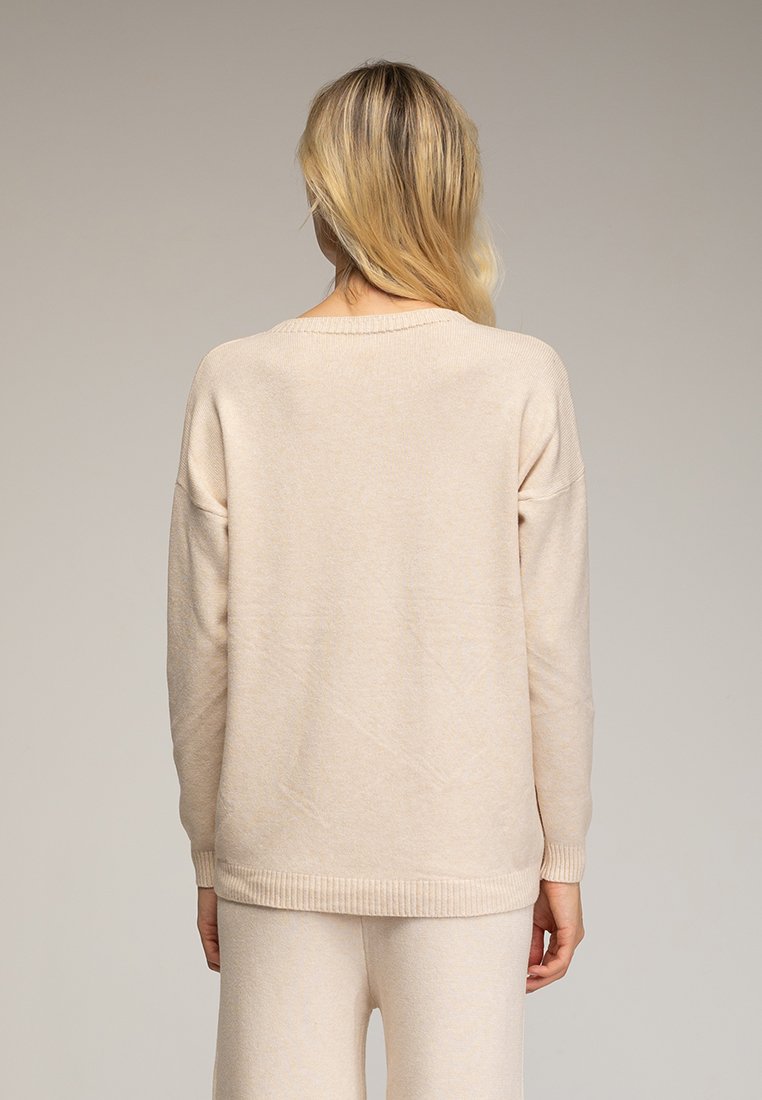 Licht beige gebreide trui met een relaxte pasvorm, geribde manchetten en zoom, en een wijd decolleté, weergegeven vanuit de achterkant met een gladde textuur.