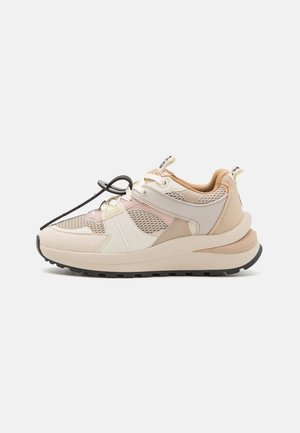 Zapatillas deportivas beige y rosa con paneles de malla, suela gruesa y acentos en negro. Cuentan con cordones y una lengüeta en la parte trasera para facilitar su colocación.