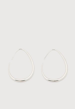 Cercei pereche, argintii, netezi, în formă de lacrimă deschisă, cu închizători subțiri din sârmă, pe un fundal alb simplu.