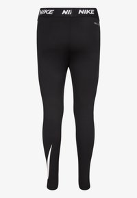 Musta urheilutrikoot, joissa on istuva muotoilu, joustava vyötärönauhassa valkoisella "NIKE"-logolla ja valkoinen koristeaukko alaosassa lahkeessa.