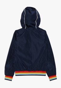 Navy blue hooded jacket with white piping on hood and rainbow-striped cuffs and waistband, shown from the back.