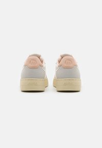 Zapatillas de color rosa pálido y gris con un reverso texturizado, materiales suaves y una suela de goma cremosa gruesa. Logotipo "mtng." grabado en el talón.