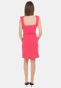 Abito aderente rosa con schiena quadrata, spalline larghe e dettaglio con zip. Progettato per una silhouette su misura, lunghezza al ginocchio.