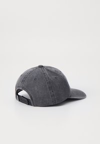 Szürke denim baseball sapka ívelt rengeteggel, állítható pánttal és enyhén kopott textúrával. Felső részen gomb található, valamint szellőzőnyílások.