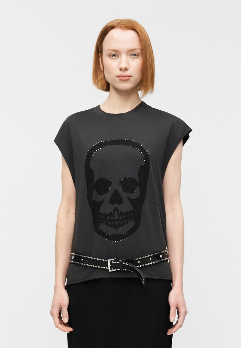 Μαύρο μπλουζάκι με μεγάλο σχέδιο κ ρανίου από παγιέτες, με κοντά μανίκια τύπου καπαρντινα και ζώνη με τρουκς στη μέση.
