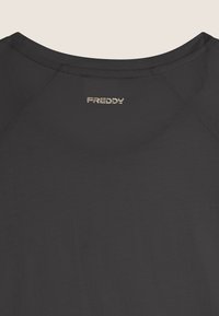 Camiseta negra con cuello redondo y mangas raglán. Logo "FREDDY" bordado en dorado en la parte superior de la espalda. Textura suave.