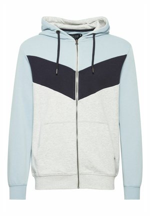 Sudadera con cremallera de color azul claro y gris con un panel en chevrón azul marino. Presenta un bolsillo tipo canguro, capucha con cordón y puños acanalados.