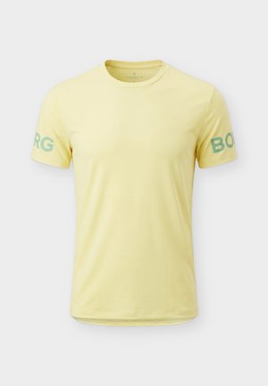 Halvány sárga rövid ujjú póló kerek nyakkivágással, zöld "BORG" felirattal, amely mindkét ujján részben látható.