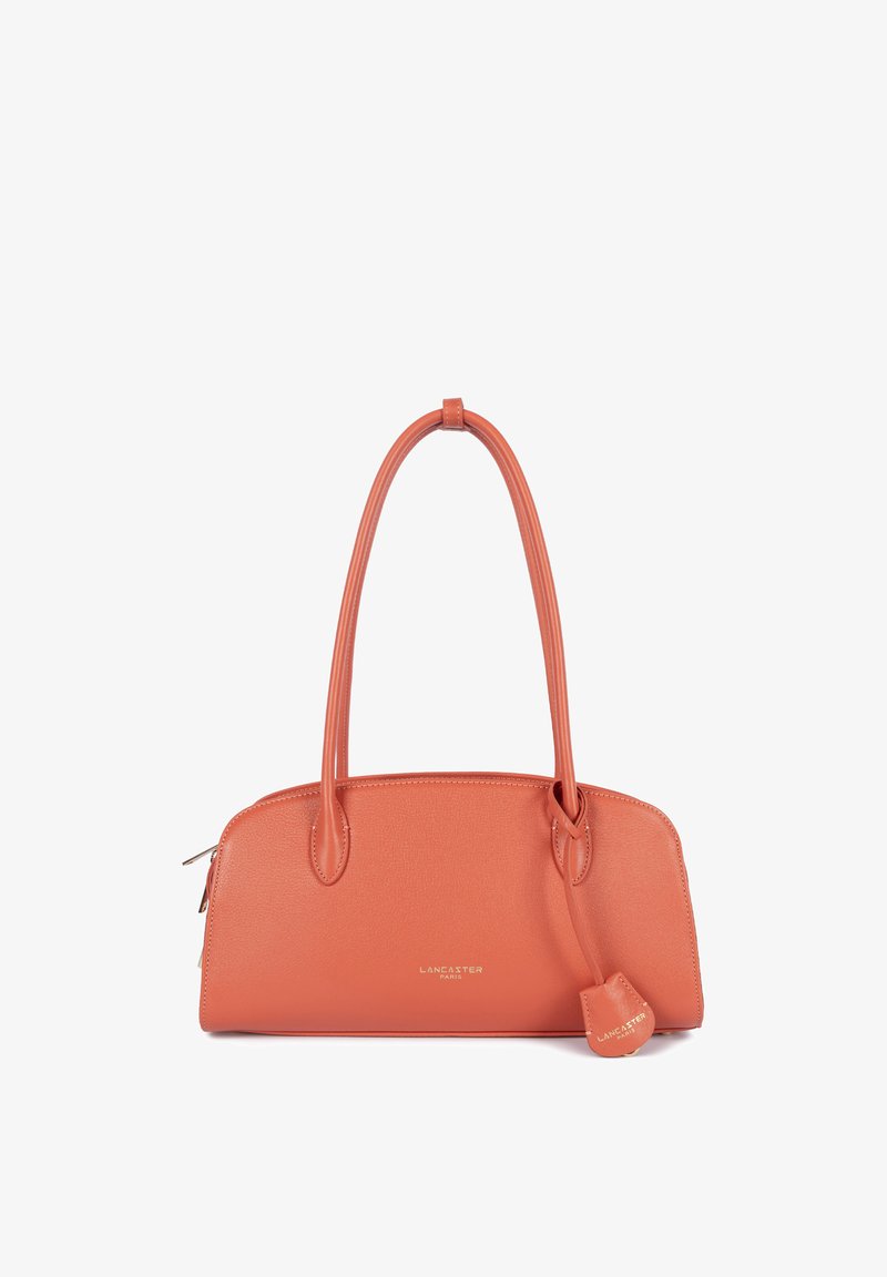 Sac à main en cuir orange corail avec deux poignées supérieures, une petite étiquette suspendue, et "Lancaster Paris" embossé en or sur le devant.
