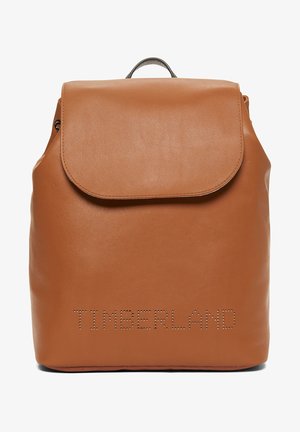Plecak z brązowej skóry z klapą i perforowanym logo "TIMBERLAND" na froncie, wyposażony w górny uchwyt do przenoszenia.