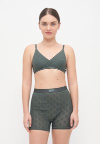 Zelena ergonomska bralette s podesivim trakama i pripadajućim visokim kratkim hlačama s teksturiranim uzorkom, izrađena od mekog materijala.