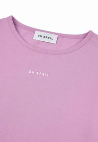 Lila majica od mekanog pamuka, s okruglim izrezom i suptilnim izvezenim logotipom "OH APRIL" u bijeloj boji na prsima.