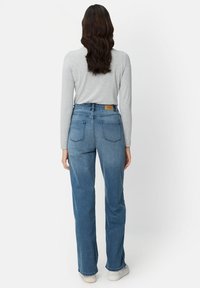 Lichtblauwe, hoge taille jeans met een rechte pijp, voorzien van achterzakken en een bruin leren label op de tailleband.