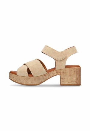 Sandale en daim beige avec deux larges brides, une bride à la cheville avec velcro, et une plateforme épaisse à talon bloc en bois.
