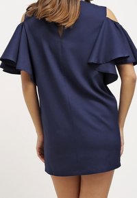Robe bleu marine avec des manches courtes en cascade à épaules dénudées, texture lisse, détail en ouverture dans le dos et coupe légèrement ample.