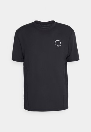 T-shirt noir à manches courtes en tissu synthétique lisse, présentant un graphique circulaire blanc sur la poitrine et un col rond.