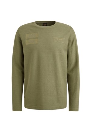 Olivno zelena majica s dolgimi rokavi iz teksturirane tkanine, ki ima dve nalepki in vezeno blagovno znamko na prsih. Okrogla izrez.