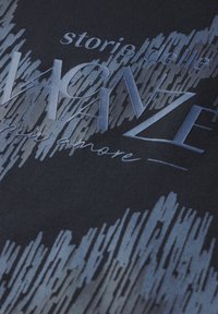 Tejido negro con un degradado de patrones de pinceladas azules. Los elementos de texto incluyen "storie delle" y "amore" en tonos contrastantes.