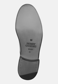 Semelle de chaussure en cuir noir avec une finition lisse, marquage en relief "HENRY STEVENS BERLIN", taille 8, et accent métallique près du talon.
