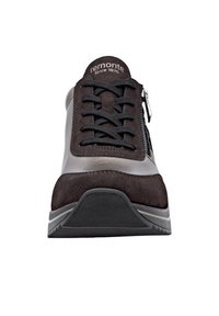 Baskets à lacets en suède marron et matériau synthétique gris, avec une fermeture éclair sur le côté, une semelle texturée et un logo discret sur la languette.
