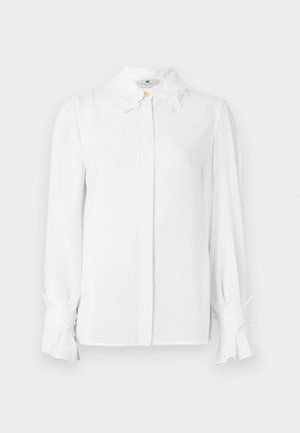 White long-sleeve blouse featuring a pointed collar with floral accents, button closure at the front, and flared cuffs. Smooth fabric texture.