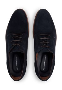 Παπούτσια από σουέντ σε ναυτικό μπλε χρώμα με καφέ λεπτομέρειες, διαθέτουν στρογγυλεμένη μύτη, σχεδιασμό με κορδόνια και προφυλακτικό με λογότυπο. Ομαλή υφή και απλή σιλουέτα.