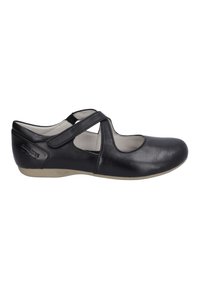 Zapatos planos de cuero negro con punta redonda, detalles recortados y una correa de velcro. Presentan una suela texturizada en color beige.