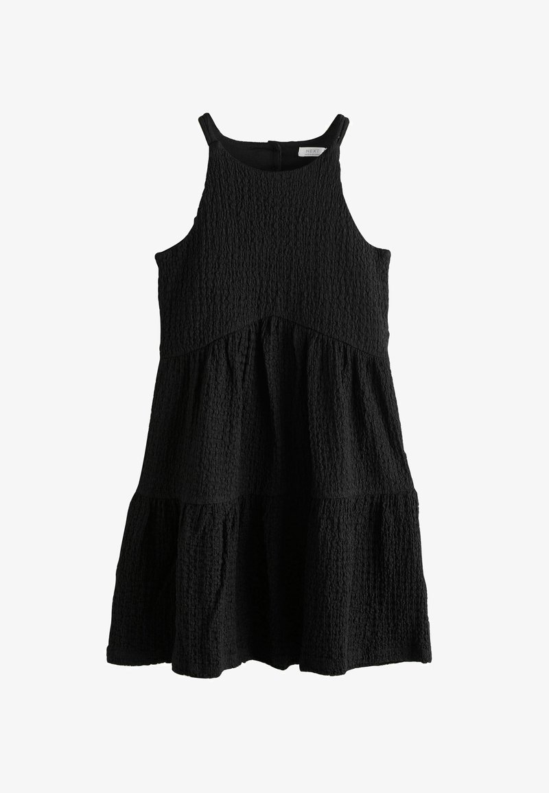 Robe noire sans manches en tissu texturé, avec un design à volants et un col arrondi. Caractérisée par une silhouette ample et fluide.