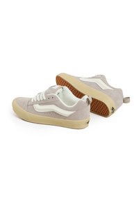 Zapatillas de ante gris claro con acentos blancos, cierre de cordones, forro interior en color crema y suela de goma con un agarre estampado.
