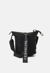 Borsa nera con motivo floreale, chiusura con zip, tracolla regolabile con testo "marimekko", texture morbida e design con la parte superiore curvata.