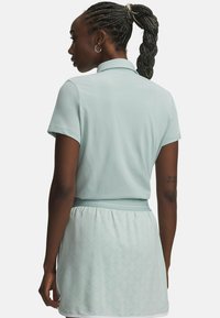 Ανοιχτό μπλε πόλο με φούστα με υφή, κοντά μανίκια και γιακά. Η φούστα έχει διακριτικό διαμάντι σχέδιο και ελαστική μέση.