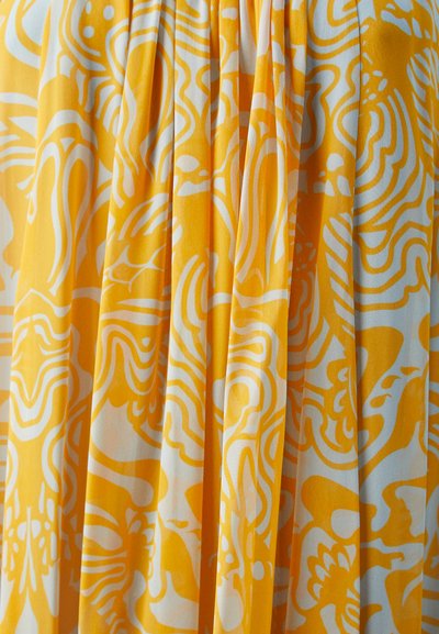 Tejido amarillo con patrones abstractos blancos, que presenta plisados que añaden textura y dimensión. Superficie suave, caída fluida.