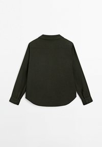 Chemise à manches longues, de couleur vert foncé, fabriquée en tissu lisse. Dispose d'un col, de poignets à boutons et d'un ourlet incurvé. Design minimaliste sans motifs.